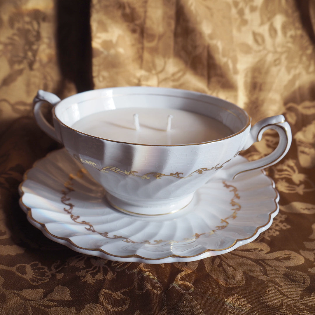 Bougie grande tasse dorée parfum agrumes gingembre, dans une tasse de collection